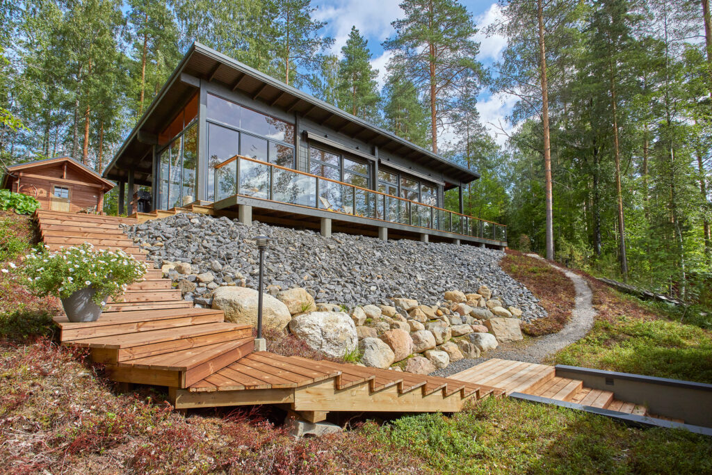 Pulpettikattoinen hirsihuvila, jonka etuseinällä on isot, korkeat ikkunat.