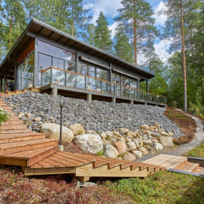 Pulpettikattoinen hirsihuvila, jonka etuseinällä on isot, korkeat ikkunat.