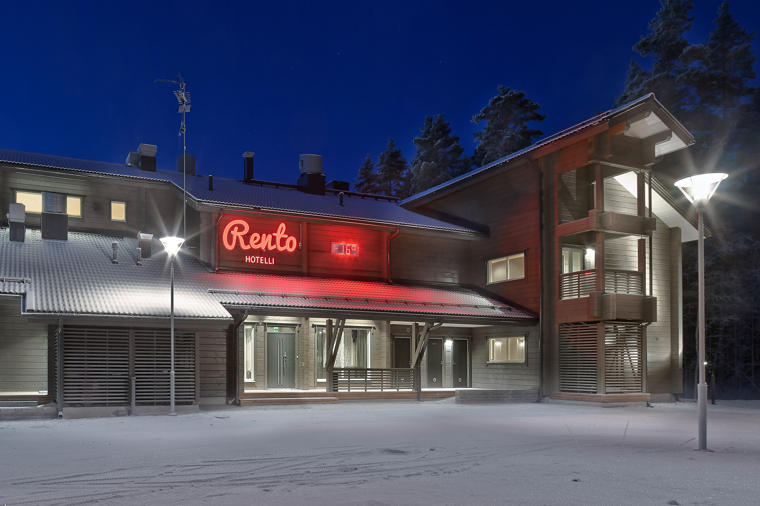 Hirsihotelli Rennon ulkokuva, jossa näkyy pääsisäänkäynnin lisäksi hotellihuonesiipi.