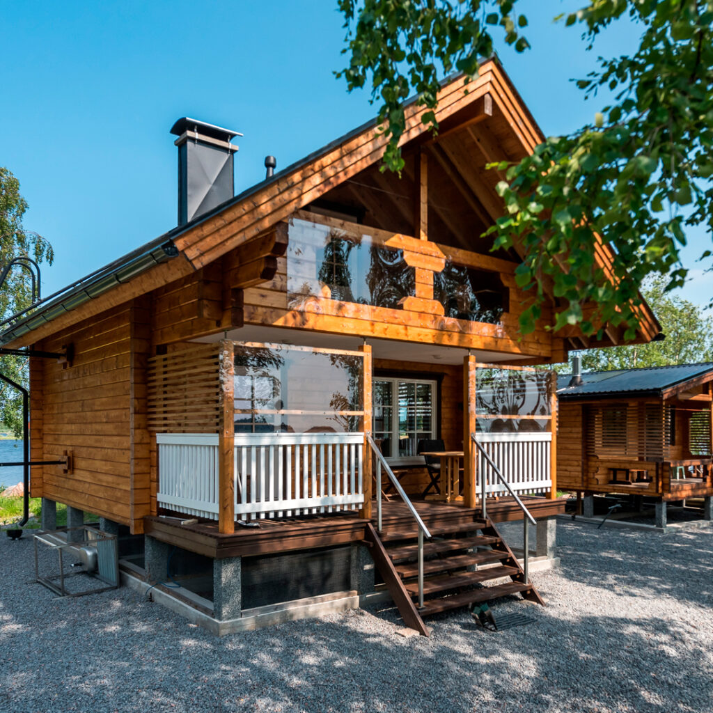 A log cabin with a loft, photographed from the outside. Its appearance is that of a truly traditional Finnish lakeside cabin with a gabled roof.