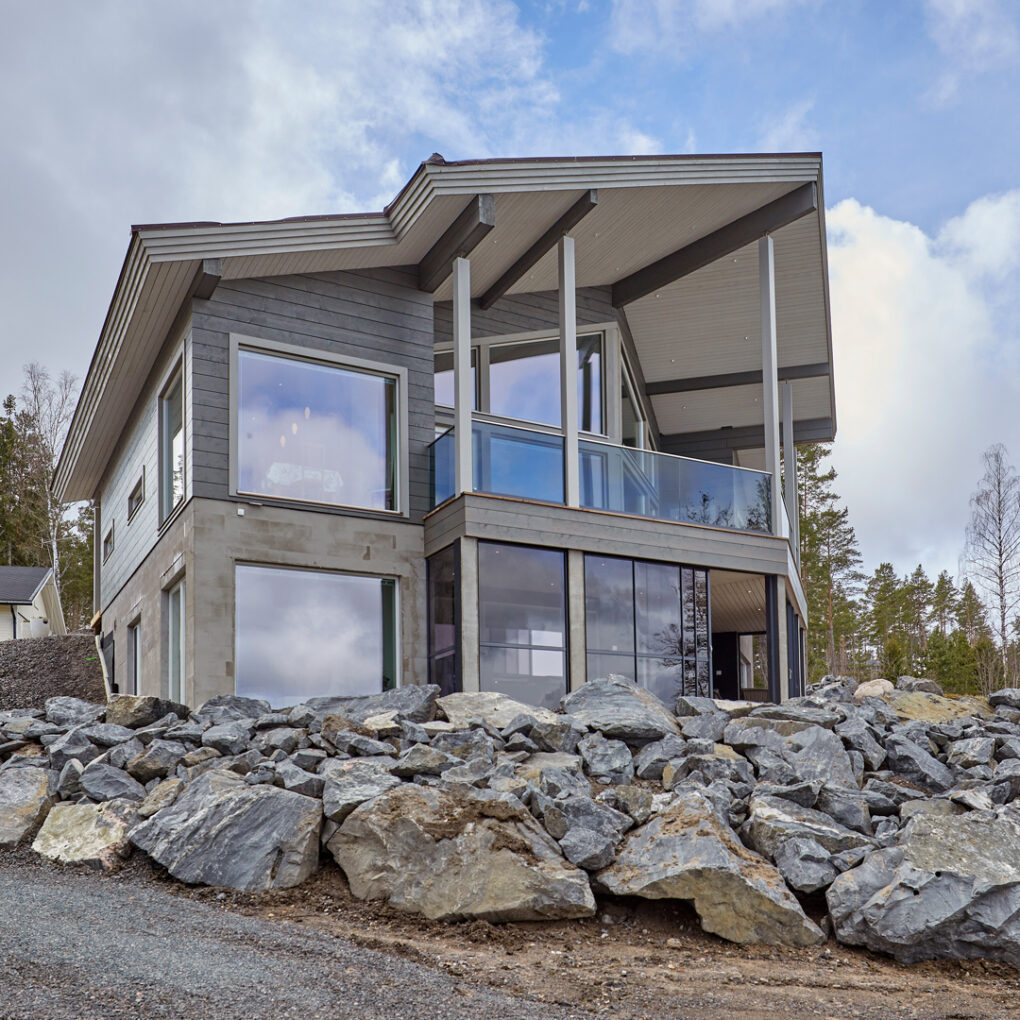 The two-storey, stately Nuuna log house. The house has been finished in grey and white.