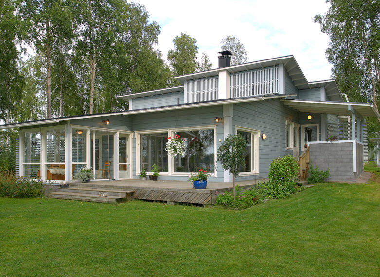 A log house with a gabled roof, where the multi-faceted roof slopes in different directions on different sides of the house.