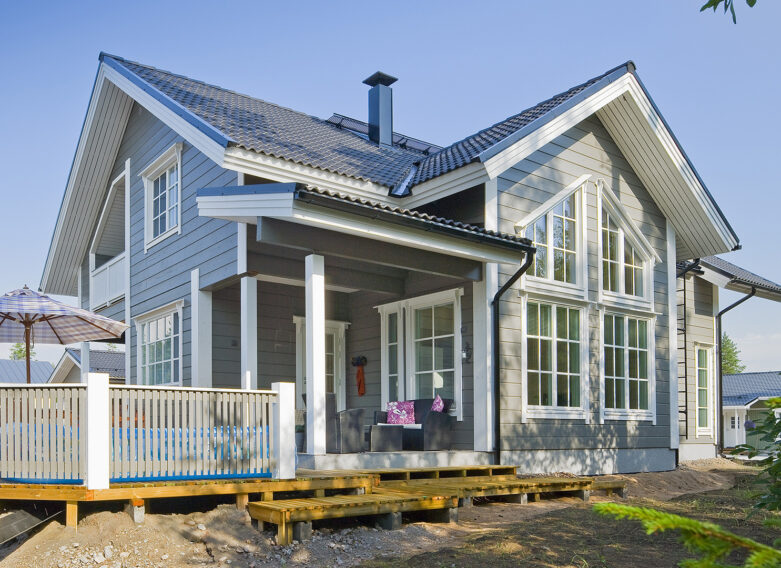 Ett 1,5-vånings timmerhus som utstrålar herrgårdsatmosfär, med stora fönster med spröjs.