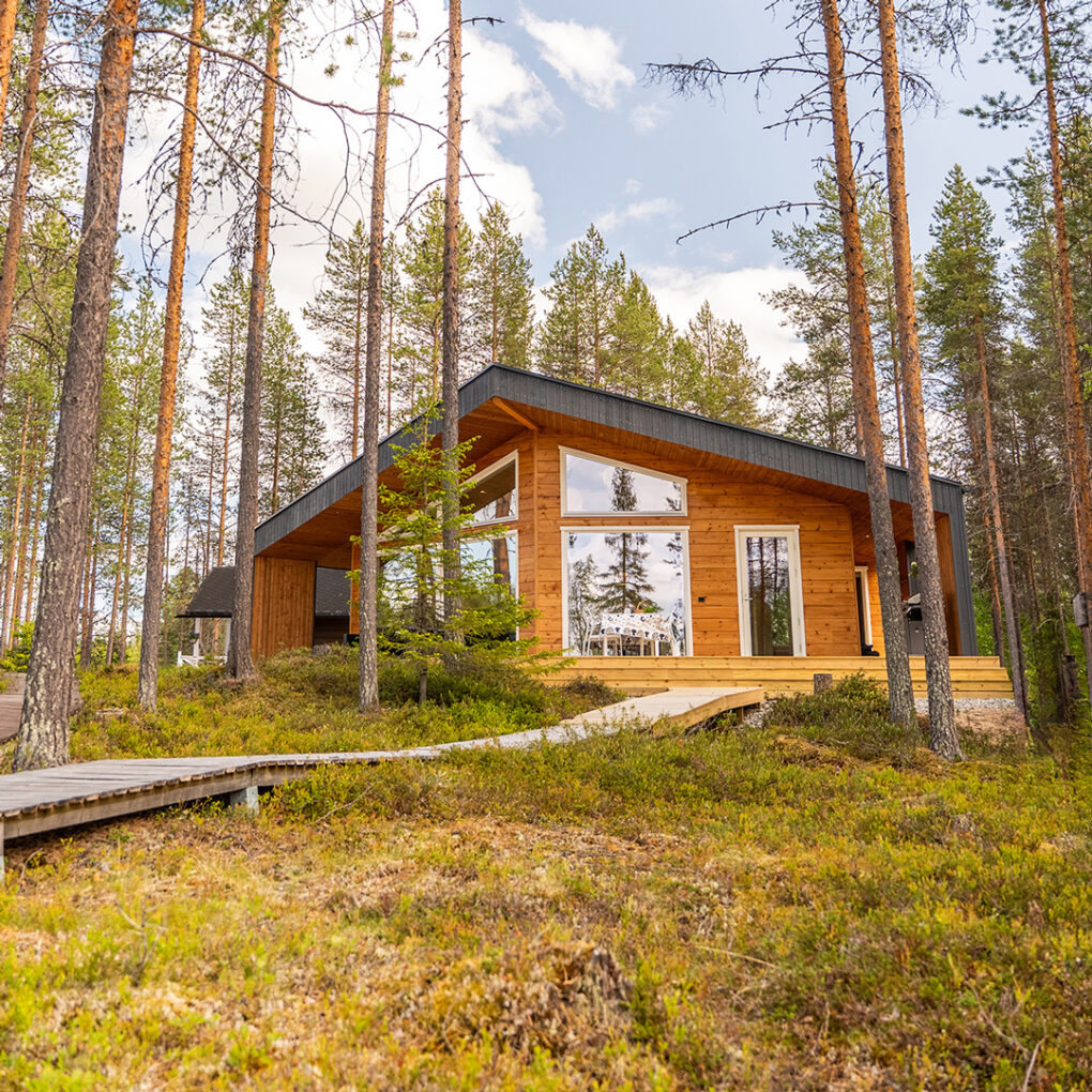 Moderni hirsihuvila Nuuna mäntymetsän keskellä.