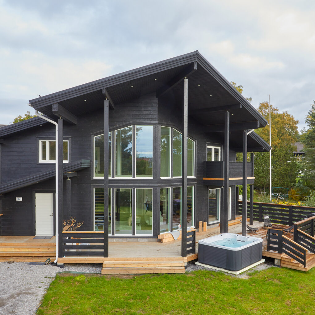 The black two-storey Nuuna charms with its elegance. There is a hot tub adjacent to the terrace.