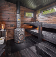 Pihasauna Saarelan sauna on käsitelty tummilla väreillä. Saunassa on pesutila samassa yhteydessä.
