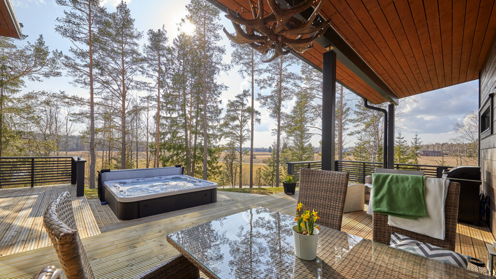 Hirsitalon terassilta avautuu maisemat avarille pelloille. Taloa suojaa kuitenkin pieni puukaistale.