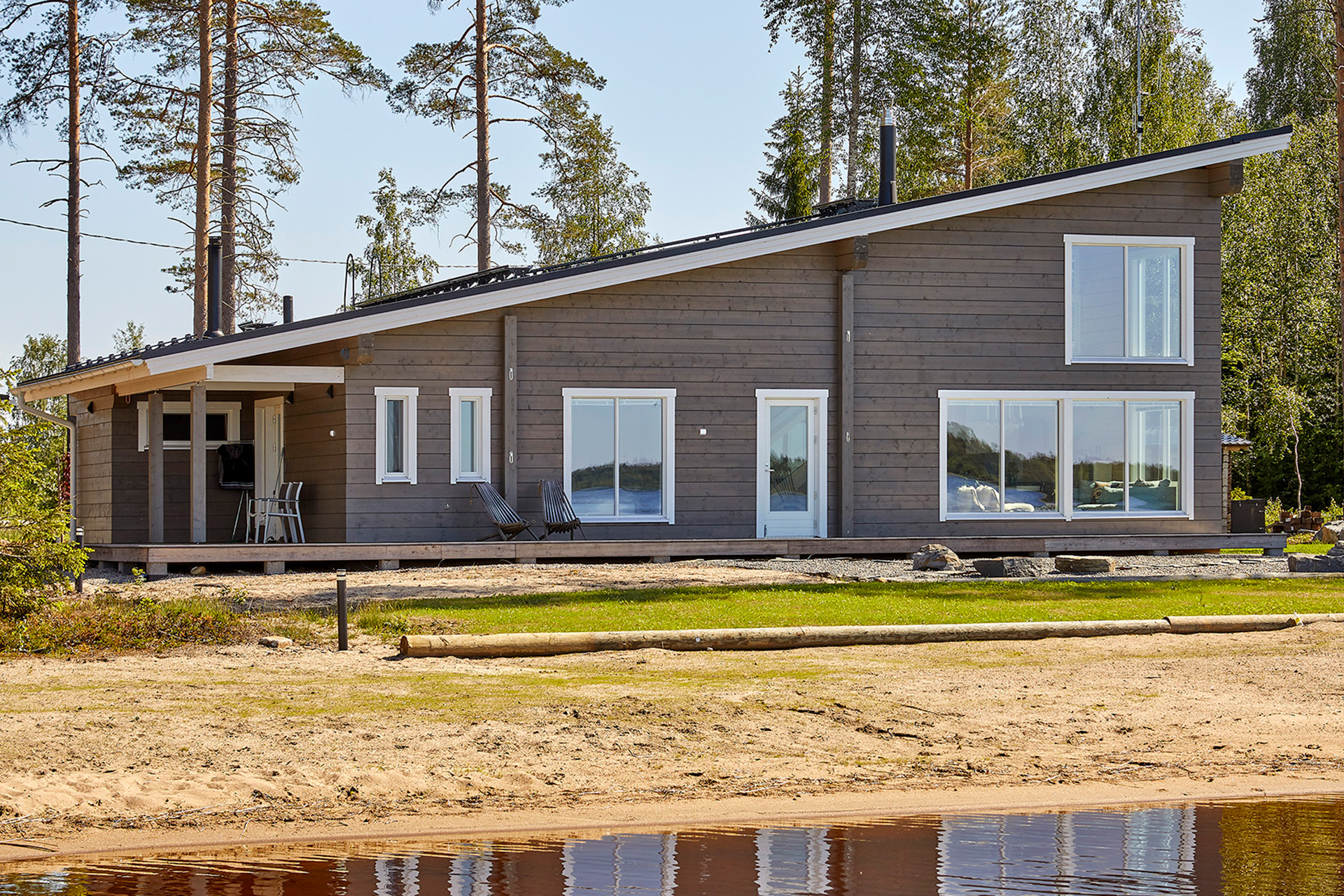 Modernt timmerhus med Pulpettak som sträcker sig längs husets längd.