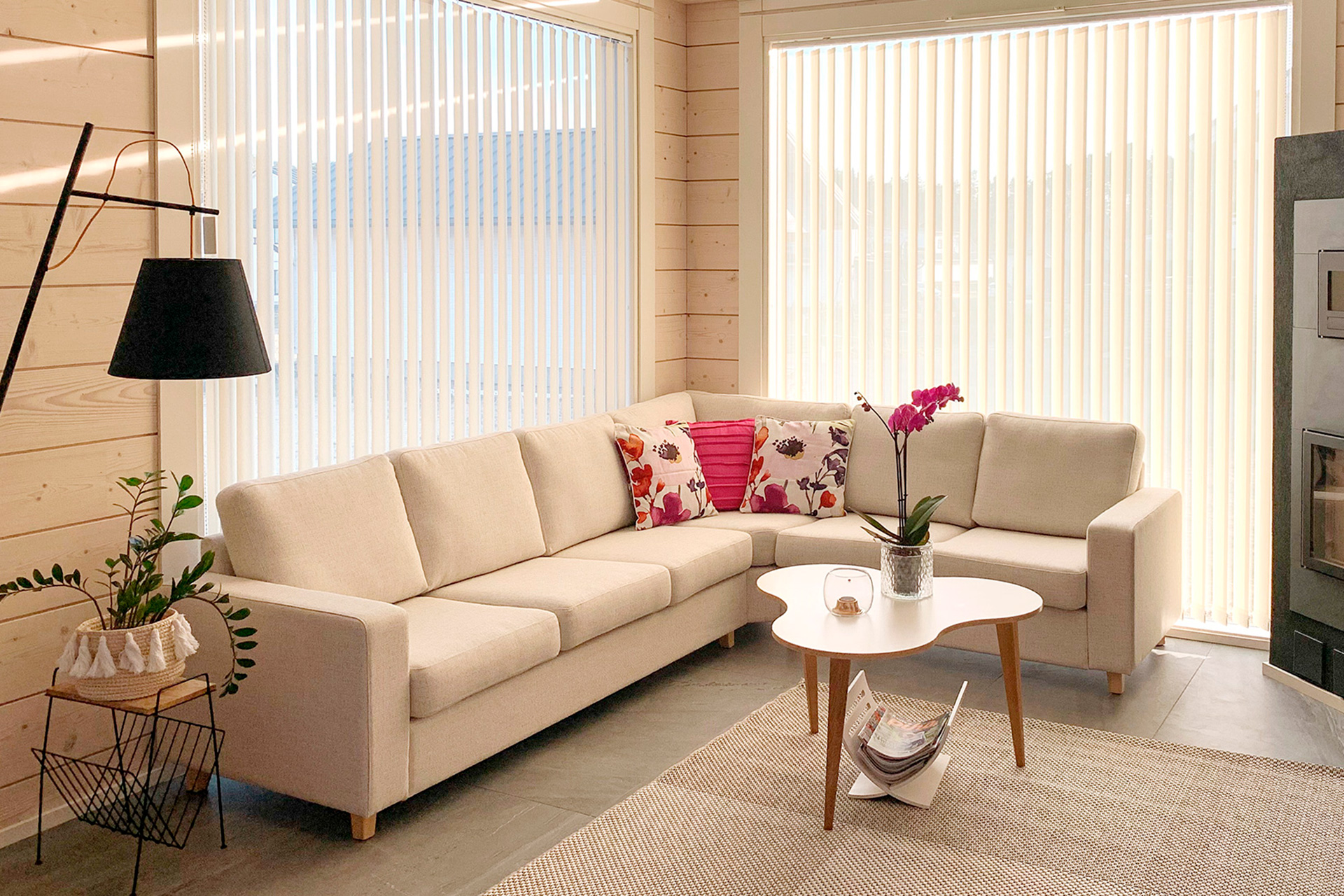 The bright living room of the log home. Light pink details have been added to complement the light tones, perfectly matching the atmosphere of the living room.
