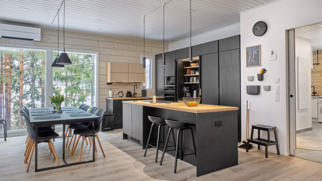 The kitchen interior is a combination of wood and black. In addition to the logs, the kitchen worktops, among other things, are made of wood.