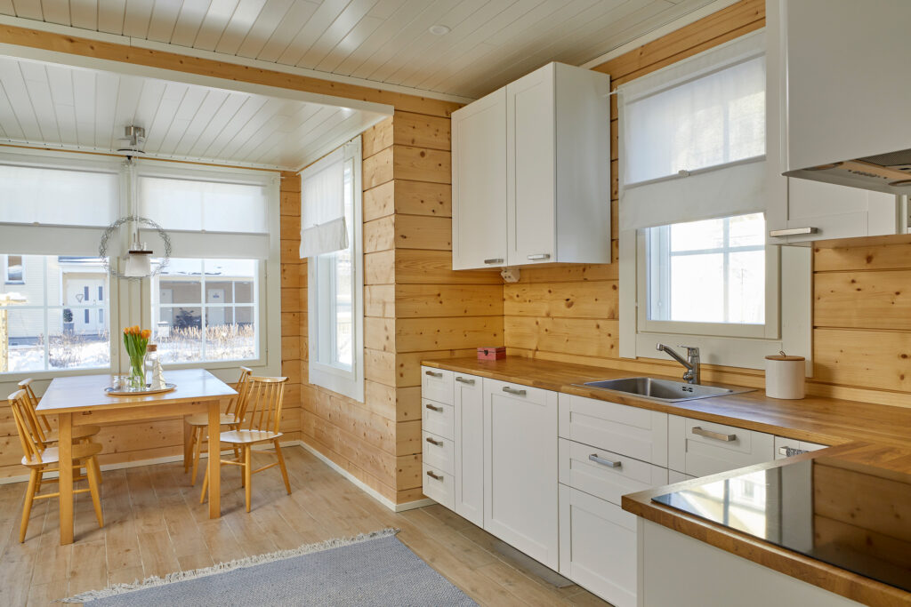 The kitchen in the log house features extensive exposed log surfaces. The sheered corner joint gives this otherwise traditional house a modern look.