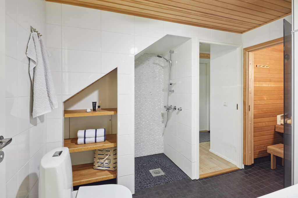 Efficient use of space in the washroom. The shower has been fitted under the stairs leading upstairs, which is why there is a small sloping ceiling above the shower.
