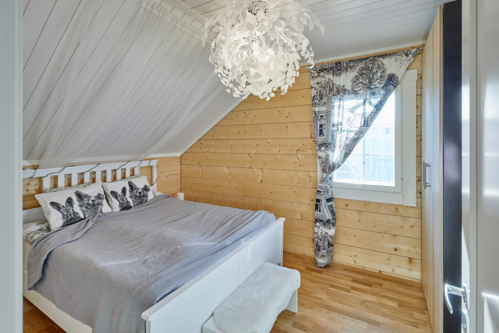 The bedroom upstairs has a sloping ceiling. The bedroom also features plenty of soothing log surfaces.