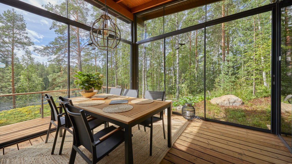 Lasitettu terassi, jossa on kuusihenkinen pöytäryhmä.