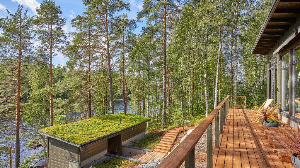 Hirihuvilan terassilta otettu kuva. Alarinteessä näkyy saunarakennus, johon on toteutettu viherkatto.