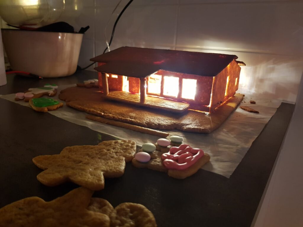 Piparkakkutalo, joka on tehty oman talon malliseksi. Talon sisälle on laitettu jouluvalot.