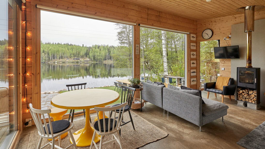 Hrisimökin tupakeittiö, jossa on lämpöä ja tunnelmaa tuova kamiina, sekä mökin henkeen sopivat kalataulut.