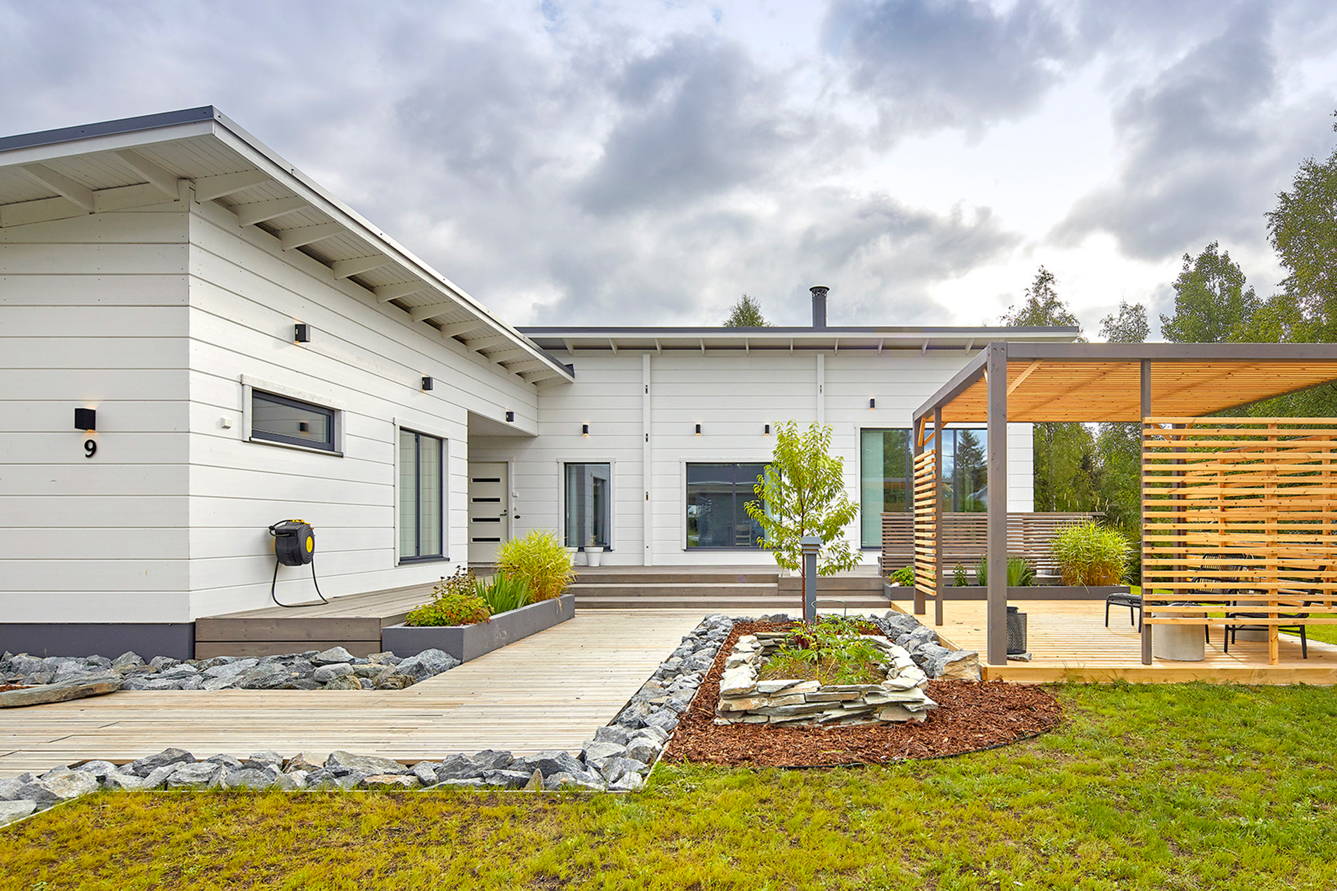 An L-shaped modern log house. The pent roof and the sheered corner joint are beautiful design features.
