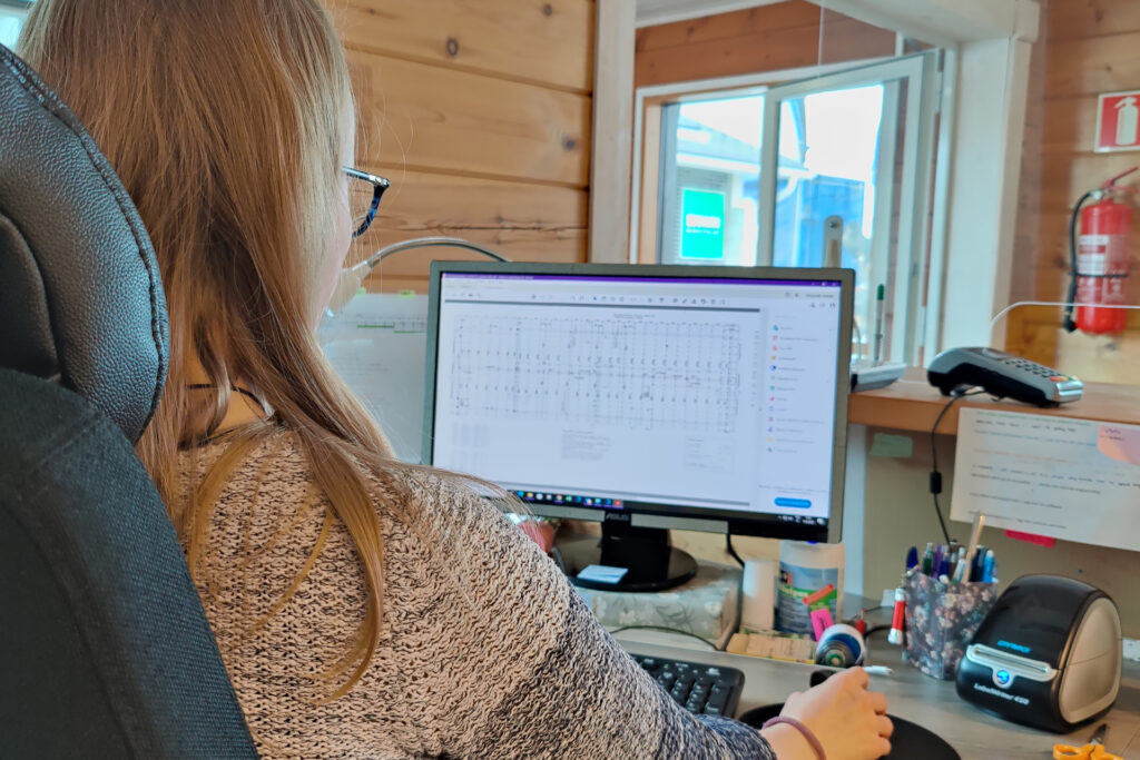 An employee at Kuusamo Log Houses sitting at their desk.