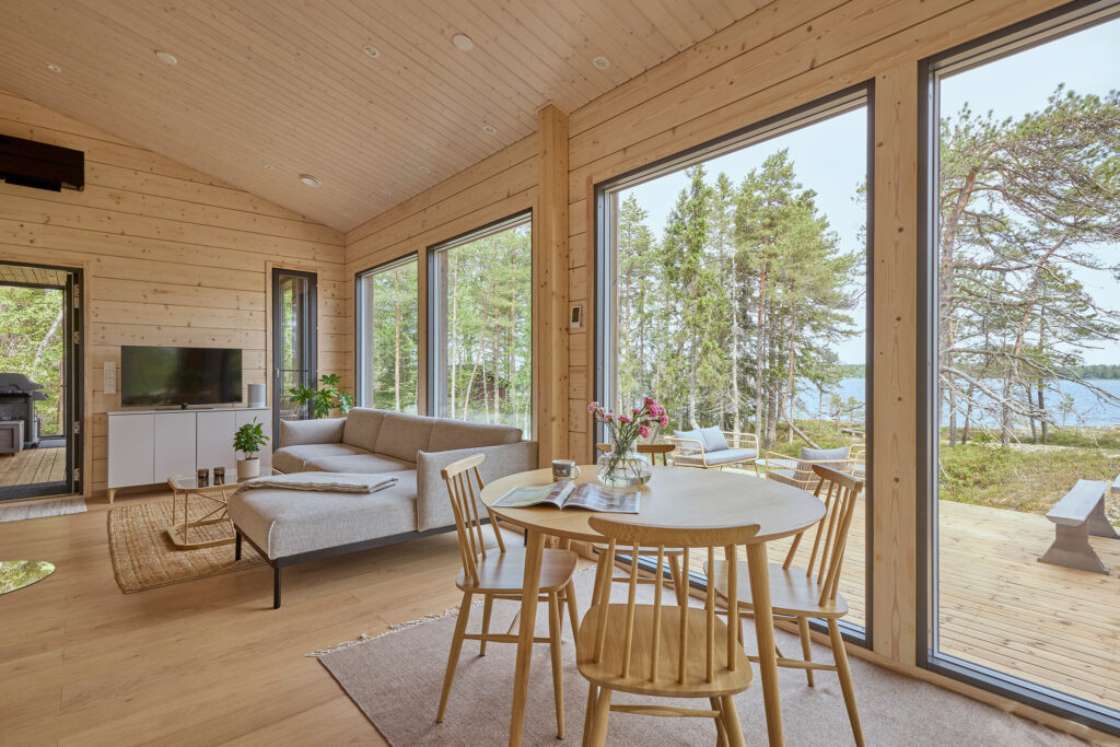 The living area of the Virkkula log villa features the large, tall windows typical of modern log houses.