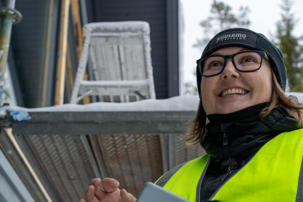 Lähikuva Kuusamo Hirsitalojen työntekijästä hirsimökkityömaalla.