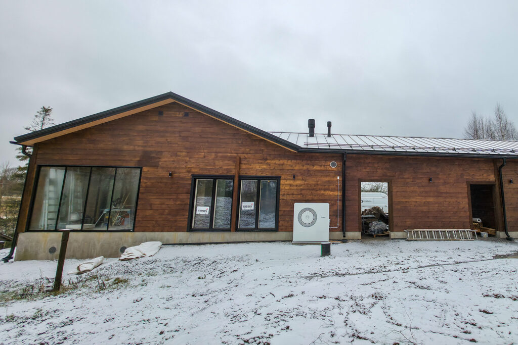 Vastavalmistuneen hirsitalon julkisivu pilvisenä talvipäivänä.